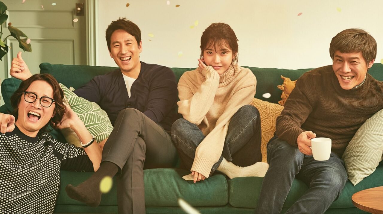 Os atores IU e Lee Sun-kyun em cena melancólica urbana.
