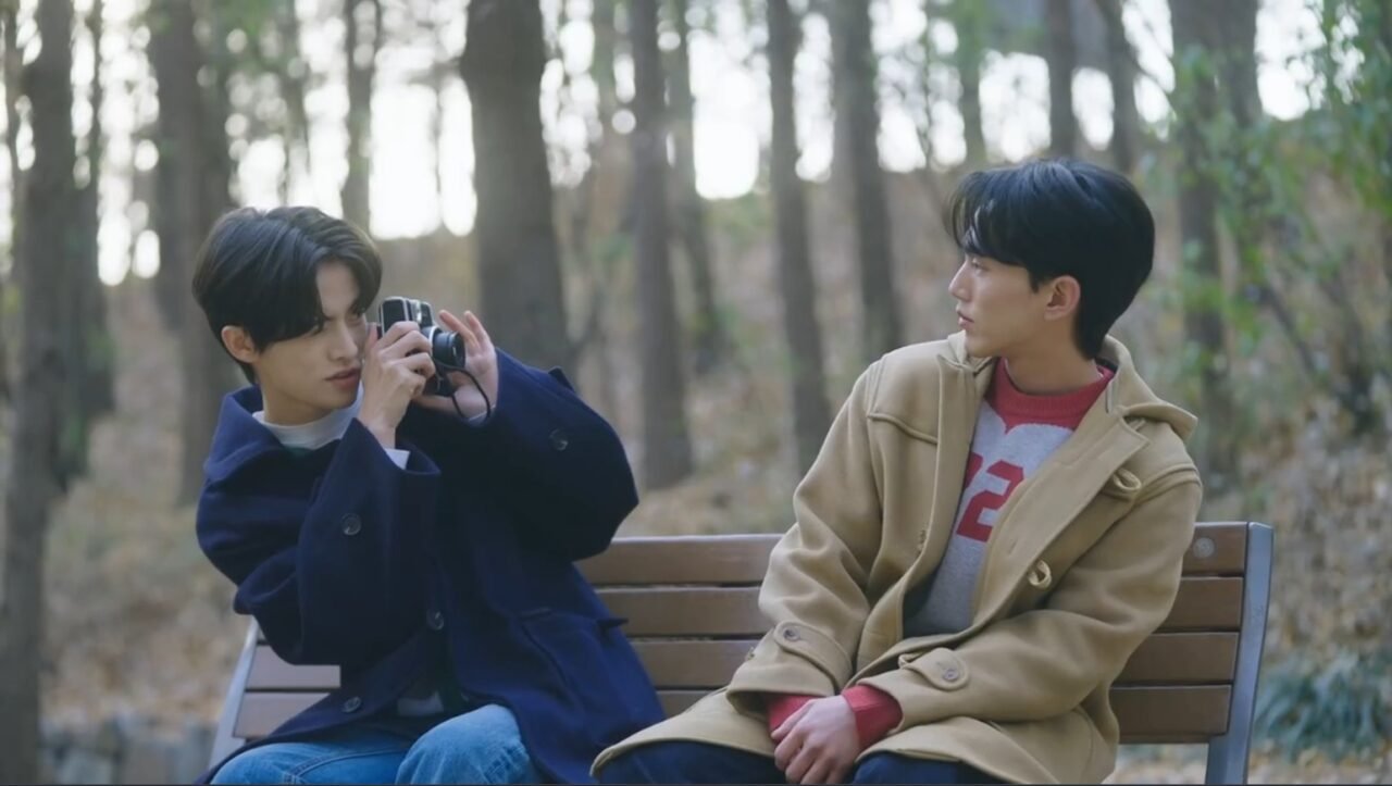Os atores Lee Woo Jin e Panutuch Saelee com expressões sérias.