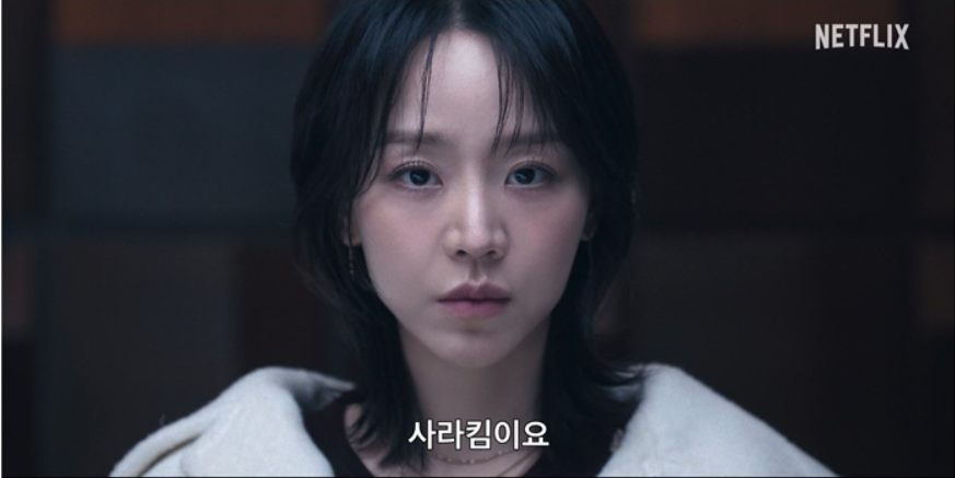 Atriz Shin Hye-sun com expressão misteriosa e roupas elegantes no dorama A Arte de Sarah da Netflix.