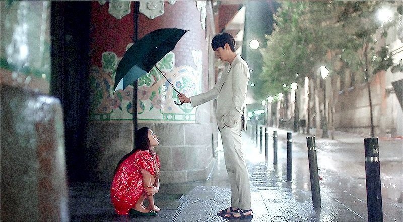 Atores Lee Min-ho e Jun Ji-hyun sob um guarda-chuva na série de fantasia The Legend of the Blue Sea.