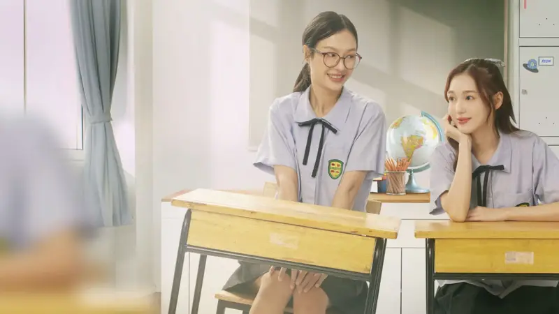 As atrizes tailandesas conhecidas como MilkLove sorrindo juntas em trajes colegiais.