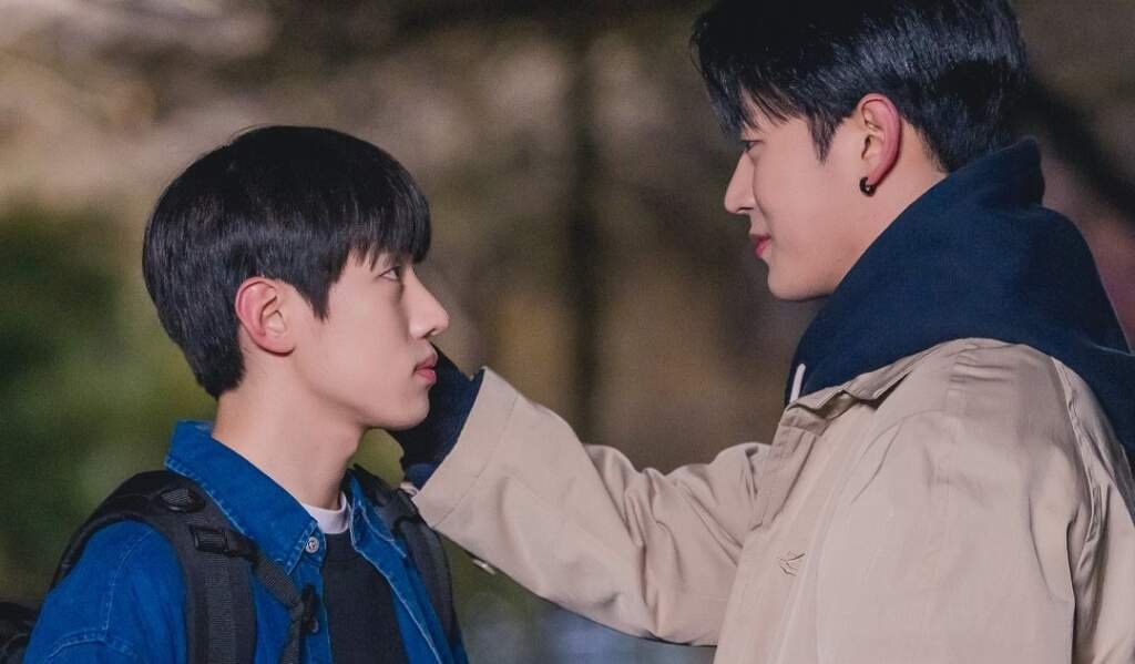 Park Seoham e JaeChan frente a frente em um beco à noite. Ele encosta JaeChan na parede com uma mão, enquanto o outro mantém o olhar firme e um leve sorriso de canto.