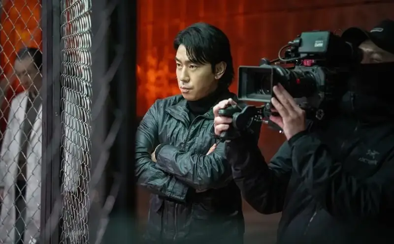 Lee Si Eon como Lee Man Bae, segurando Yoon So Yeon pelo pescoço com uma faca na mão.