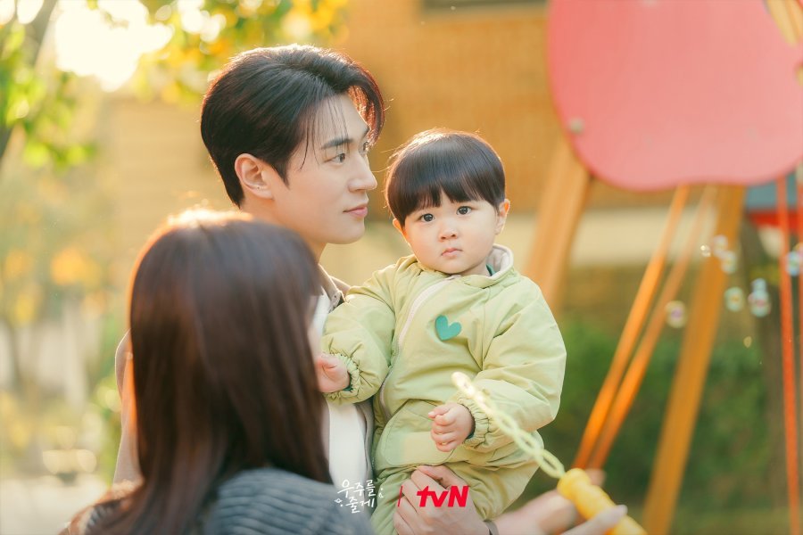Cena de Nosso Universo mostrando Hyun-jin e Tae-hyung cuidando do bebê Woo-joo.