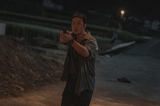 o detetive interpretado por Park Hae-soo analisando pistas em cena de O Espantalho