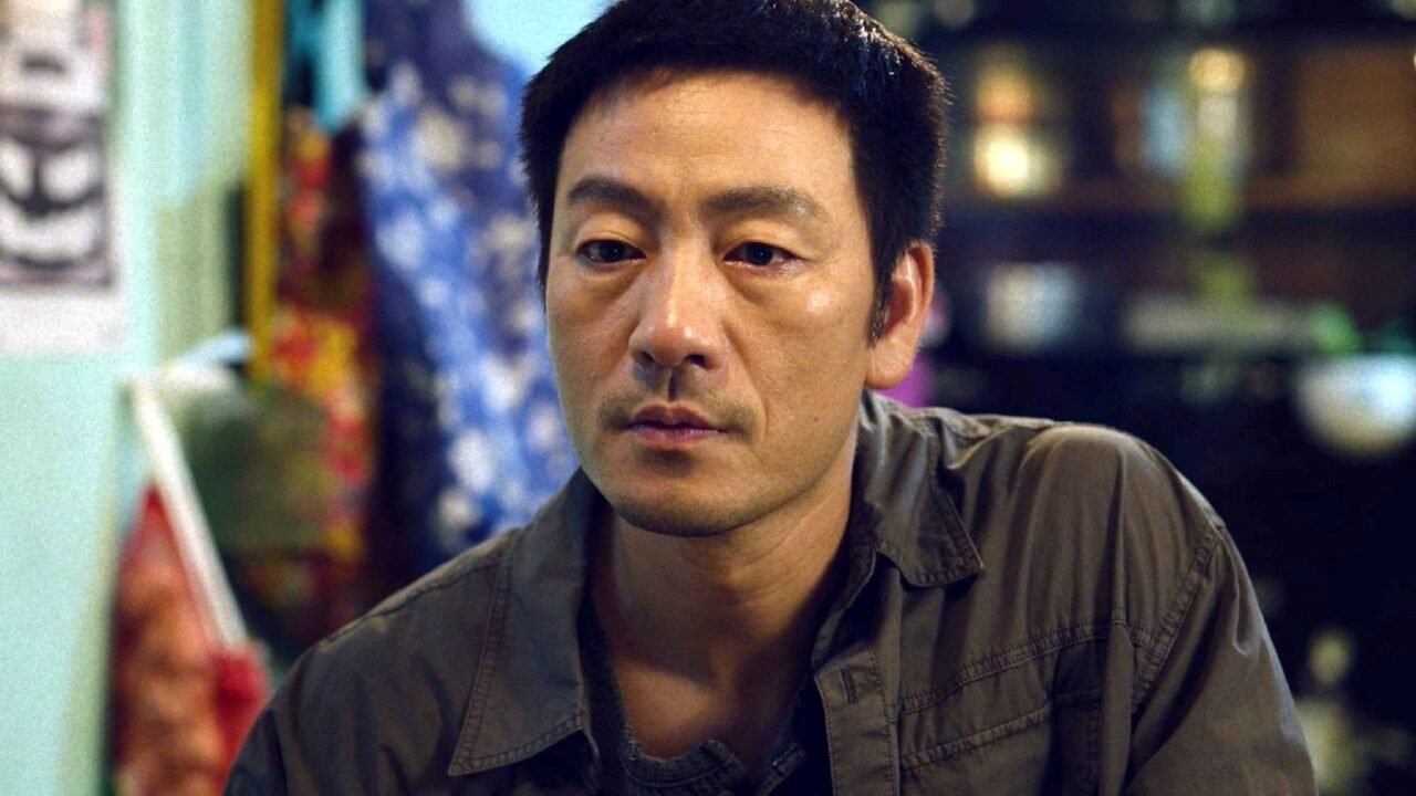 Ator sul-coreano com semblante tenso analisando um cenário investigativo.