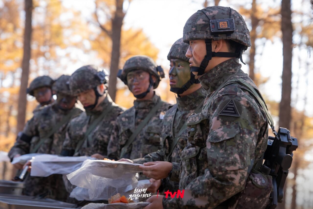 Soldado com equipamentos antigos em uma cozinha de refeitório.