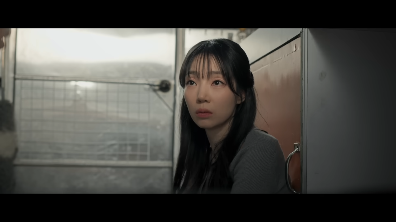 A atriz coreana Yulee Choi sorrindo em um cenário de filmagem.