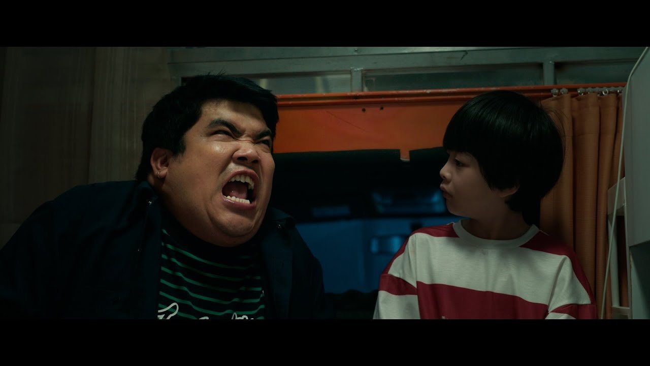 Ator Mario Maurer olhando surpreso para uma criança pequena.