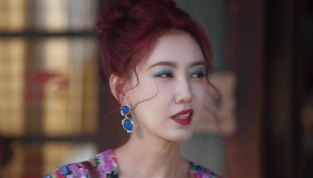 Atriz chinesa com maquiagem expressiva e fisionomia atenta.