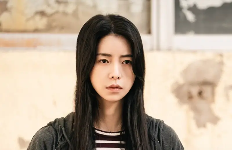 Lim Ji-yeon com aparência abatida, sem maquiagem, em um ambiente doméstico opressivo