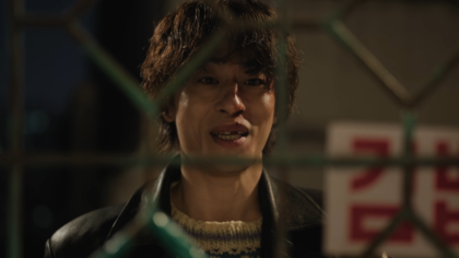 O ator Koo Kyo Hwan caracterizado como o diretor Hwang Dong Man com olhar cansado.