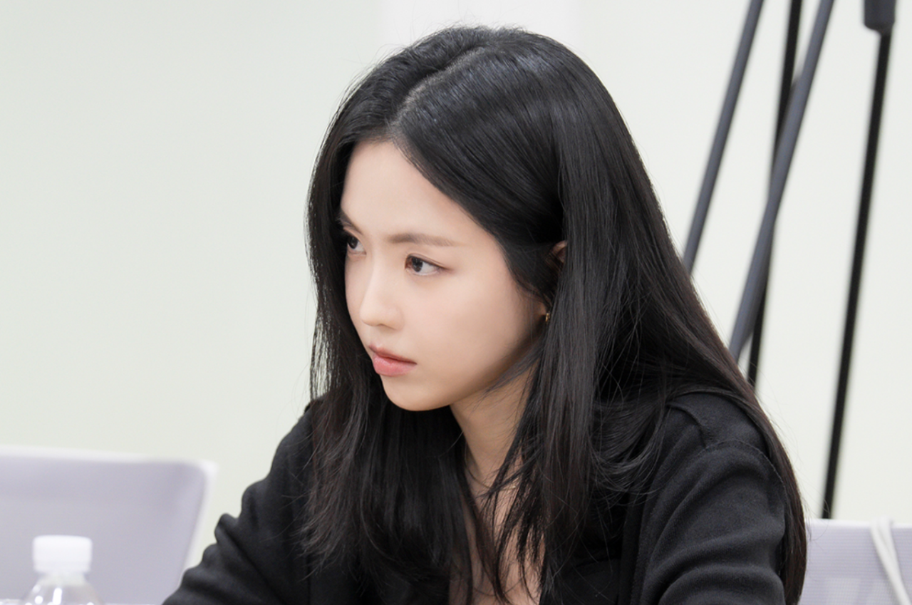 Son Na Eun caracterizada como funcionária de escritório com olhar atento.