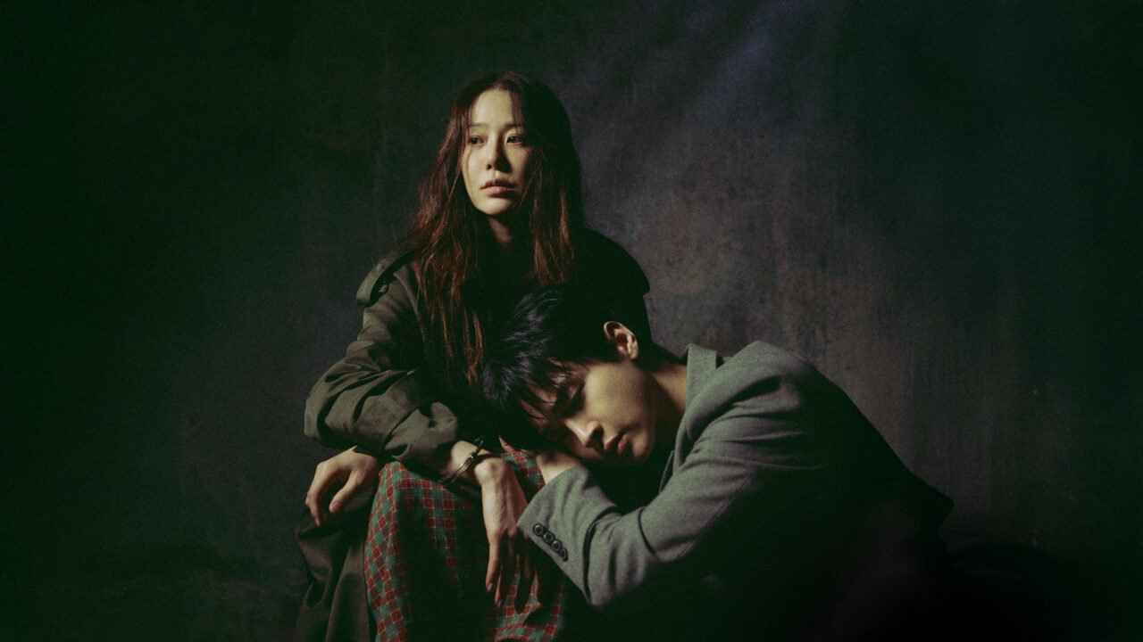 A atriz Go Hyun-jung e o ator Jang Dong-yoon se encarando através de um vidro de visitação.