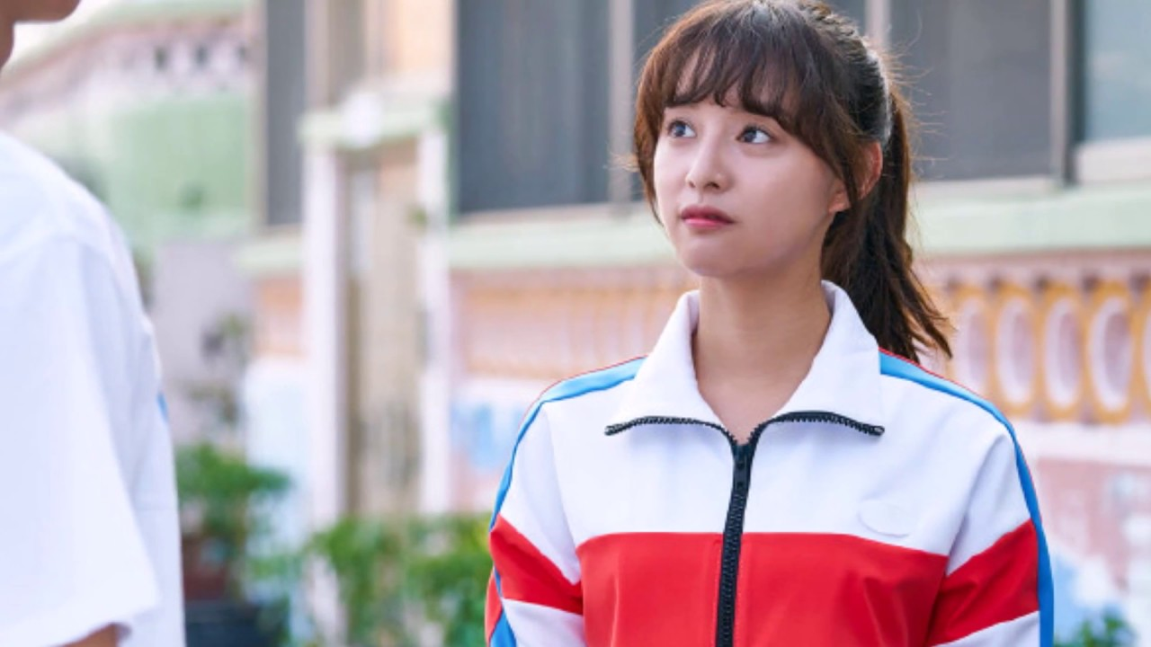 A personagem Choi Ae-ra falando ao microfone de forma animada.