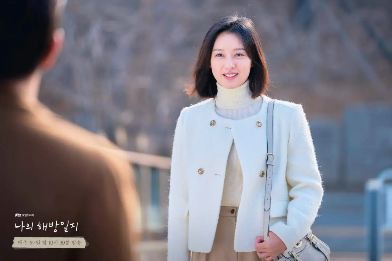 A personagem Yeom Mi-jung observando a paisagem com semblante cansado.