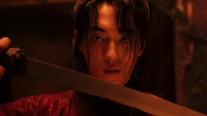 O ator Nam Joo-hyuk no papel do caçador de fantasmas Gu-cheon, entrando em um lago escuro com uma corda no pescoço e galhos de pêssego nas costas em cena da série A Leste do Palácio