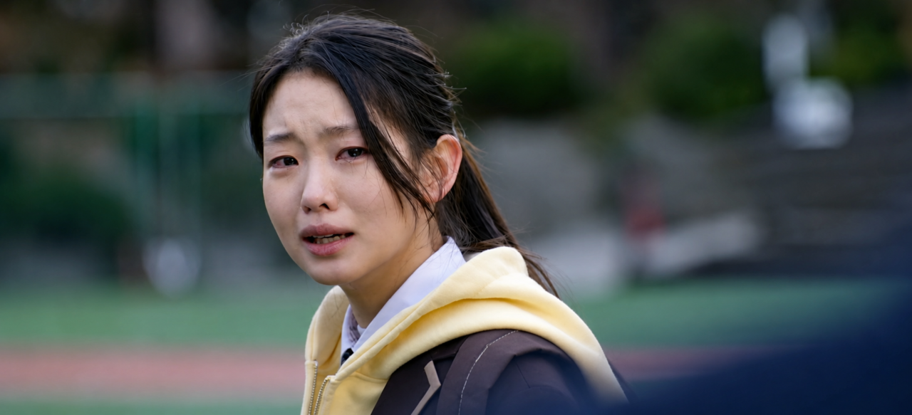 A estudante Kim Min Ji isolada no ambiente escolar, evidenciando o desgaste psicológico causado pelos episódios de bullying.