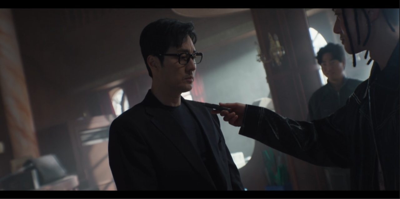Cena de Agente Kim analisando pistas durante o terceiro episódio da série.
