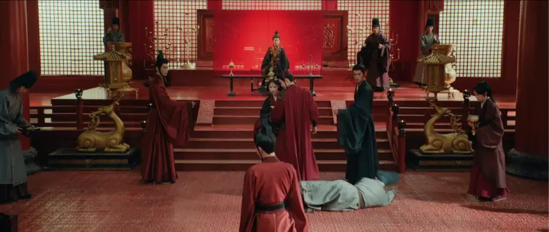 Atriz chinesa em postura formal diante de um trono imperial.