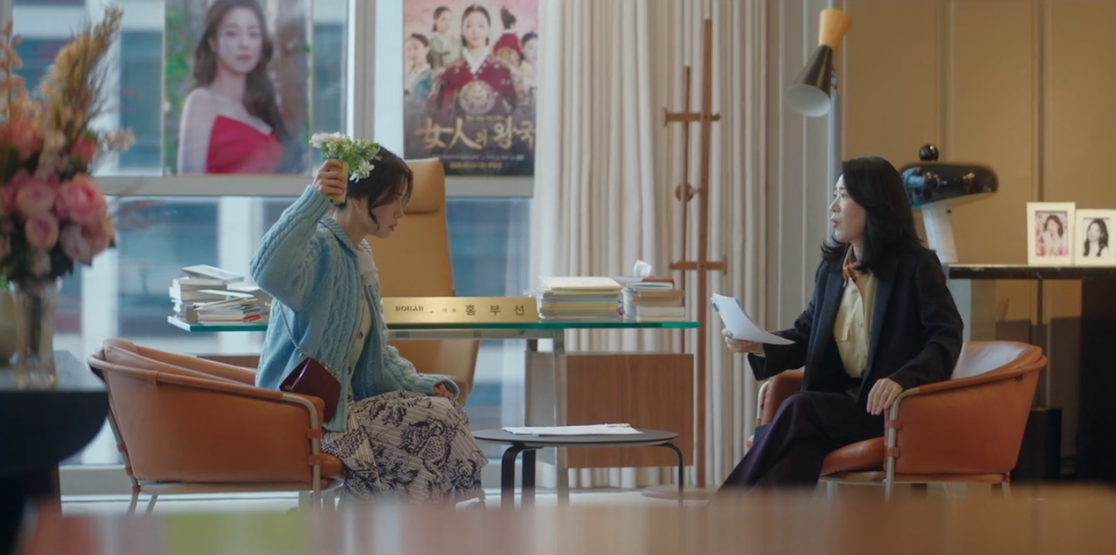 Atriz sul-coreana em ambiente moderno de escritório, conversando de forma assertiva.