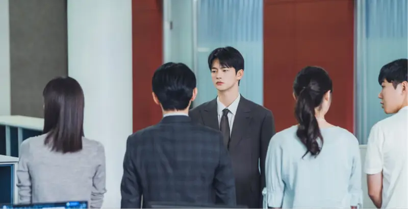 Ator sul-coreano vestido formalmente com feição de autoridade.