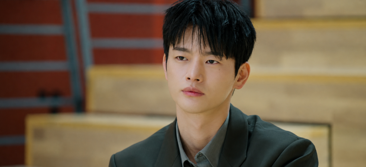  Kang Si Woo com expressão séria no ambiente corporativo da Saeum Electronics