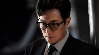 O ator So Ji Sub em cena de ação investigativa caracterizado como o protagonista de Agente Kim: Reativado