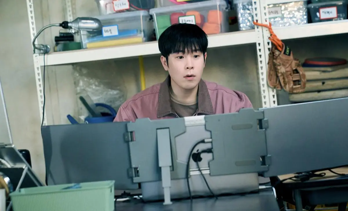 Inspetor Bong Geun Dae trabalhando com seriedade cercado por monitores em Aprendendo a Lição