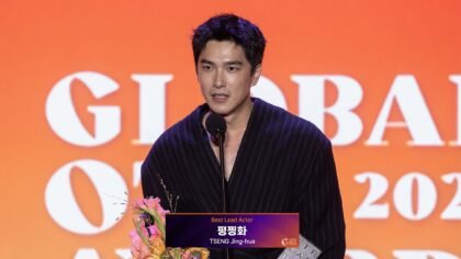 O ator taiwanês Tseng Jing-hua segurando o troféu de Melhor Ator no palco da premiação em Busan
