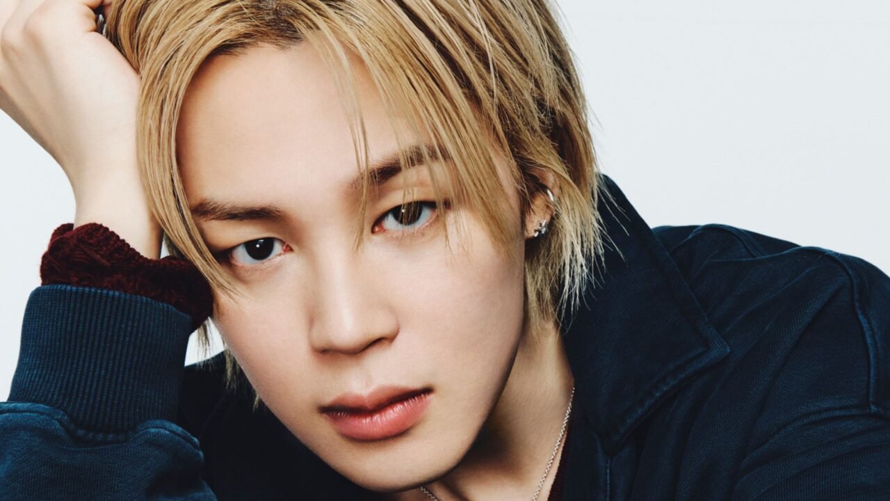 O cantor Jimin em imagem promocional para o álbum MUSE, com olhar direto e figurino escuro
