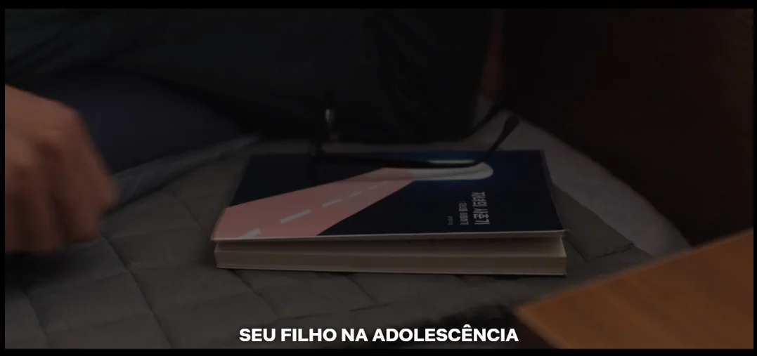 Detalhe de livro apoiado sobre a cama no quarto do protagonista.