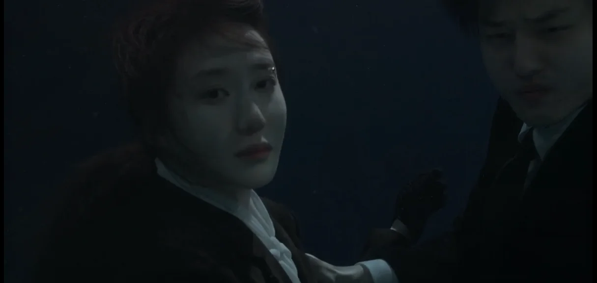 Os protagonistas caídos na água encontrando um corpo submerso no final do episódio.