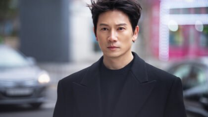 O ator Ji Sung com expressão séria e calculista em cena do dorama The Apartment Job.