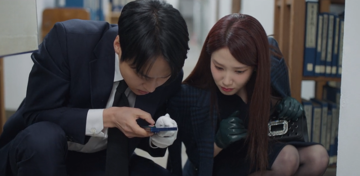Cheon Yeo Ri e Ma Gang Uk avaliando os indícios do crime.
