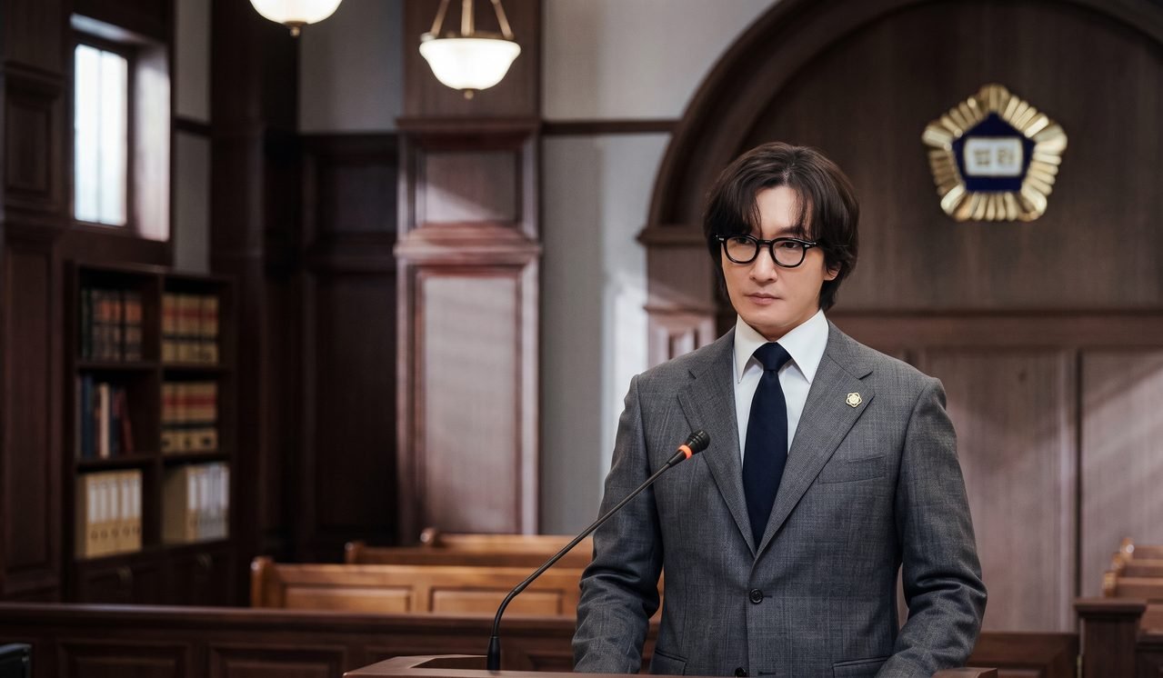 Cho Seung Woo engravatado no papel do advogado Shin Sung Han.