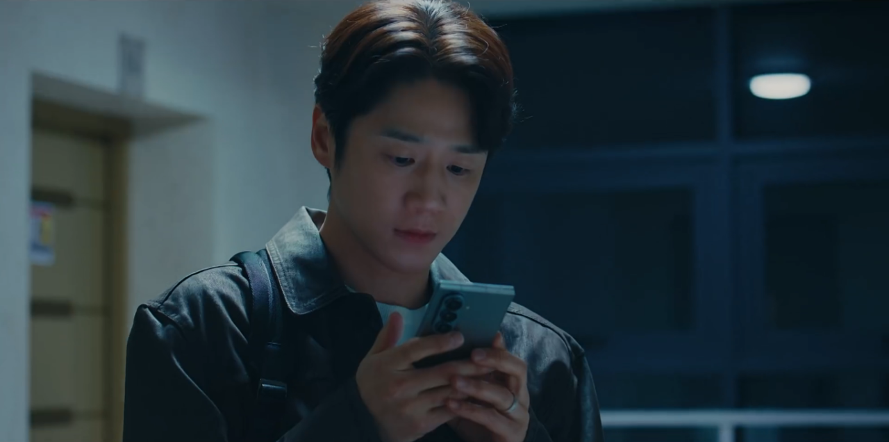 Kwon Tae Seong lendo a tela do celular no dorama.