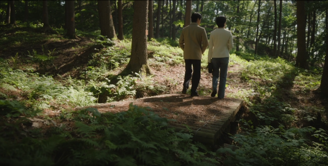 Tae-joo e Se-yoon caminhando juntos na floresta