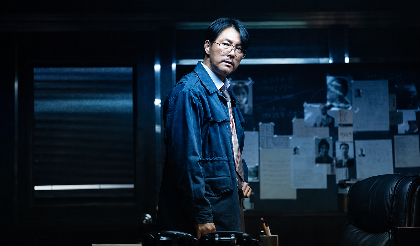 Jung Woo-sung como Jang Geon-young frente a un panel de investigación en Made in Korea 2