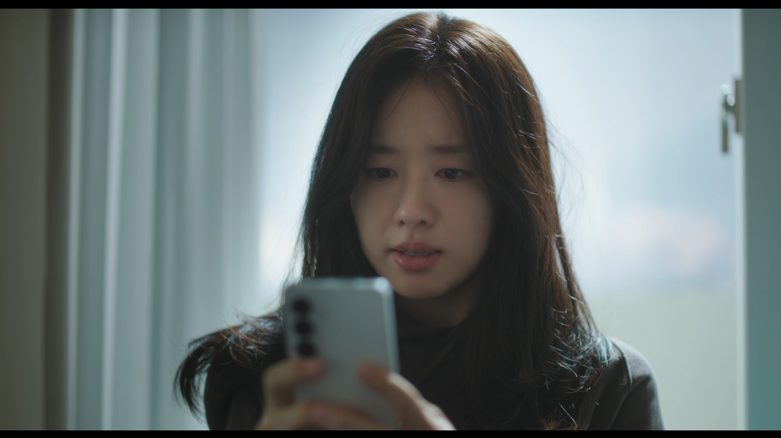 Lee Mi-do no episódio 2 de Um Amor Diferente do Seu Lee Mi-do olha para o celular durante um momento difícil no episódio 2